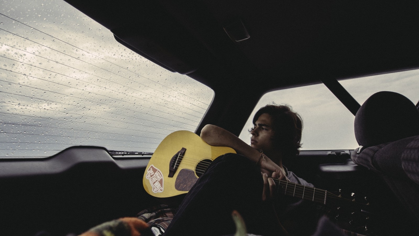 Песня едем на шине. Гитара в машине. Что такое гитара в автомобиле. Музыканты путешествуют в машин. Парень на машине с гитарой.